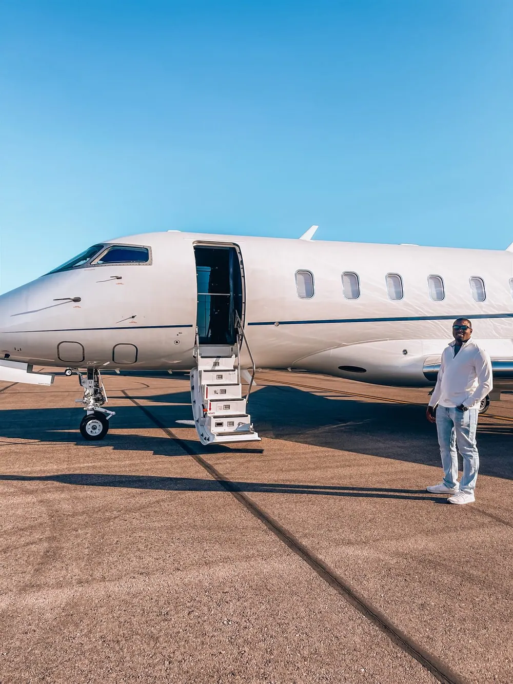 Cam Parker beside a private jet with its boarding stairs open