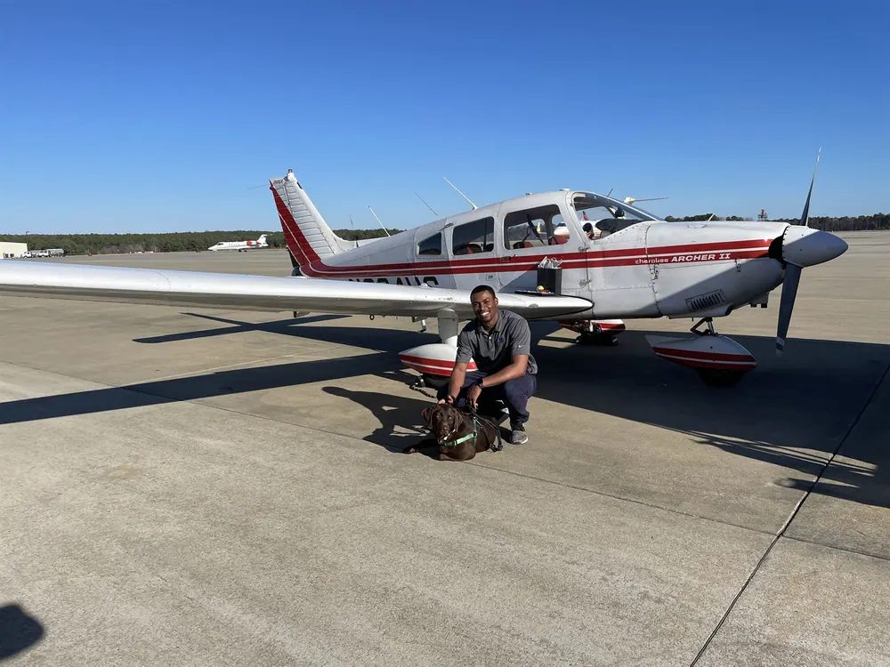 Cam Parker beside a Piper aircraft